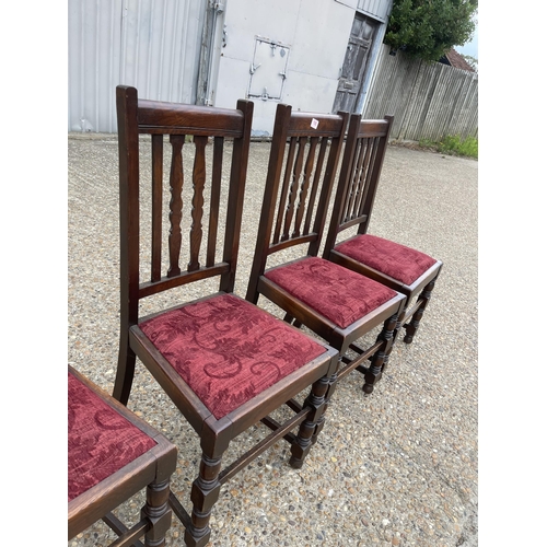 198 - A set of four early 20th century oak dining chairs with red upholstered drop in seats