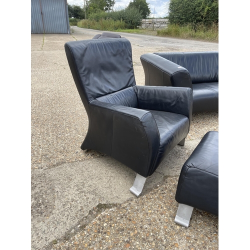 217 - A designer black leather sofa, armchair and stool by ROLF BENZ