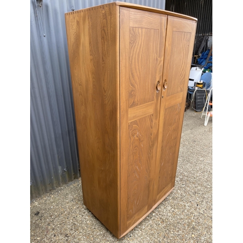 240 - An ercol light elm double wardrobe