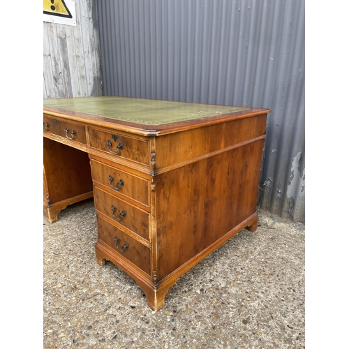 247 - A reproduction yew wood twin pedestal partners desk with drawers to the front and cupboards to the r... 