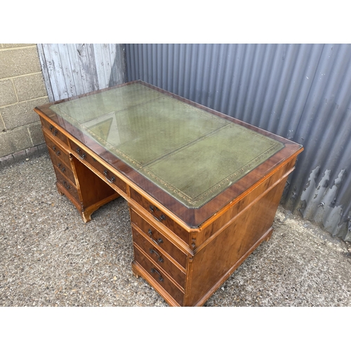 252 - A reproduction yew wood twin pedestal partners desk with drawers to the front and cupboards to the r... 