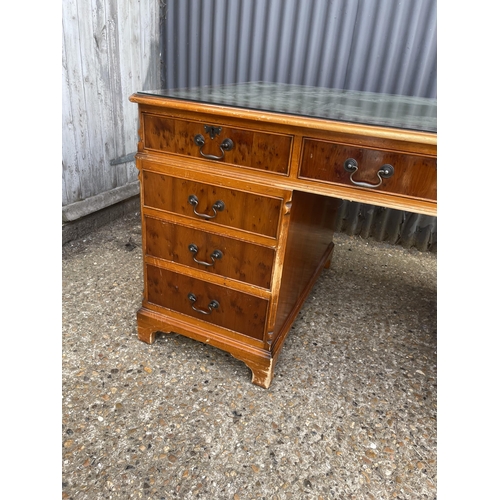 252 - A reproduction yew wood twin pedestal partners desk with drawers to the front and cupboards to the r... 