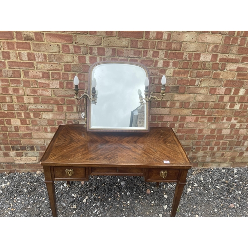 28 - A continental mahogany three drawer dressing table with brass lamps either side of a swing mirror