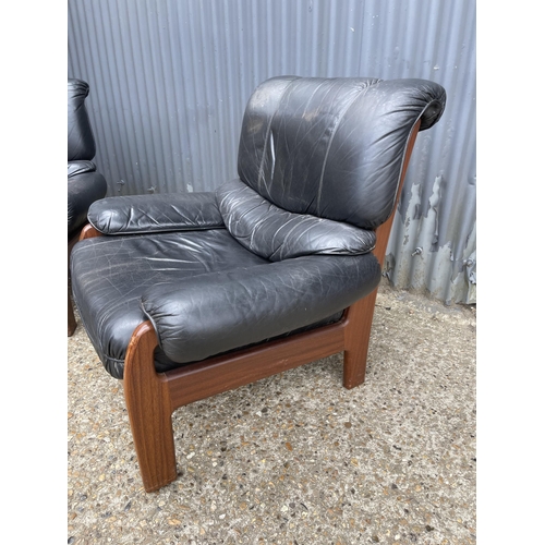 296 - A pair of mid 20th century teak framed armchairs with black leather seats