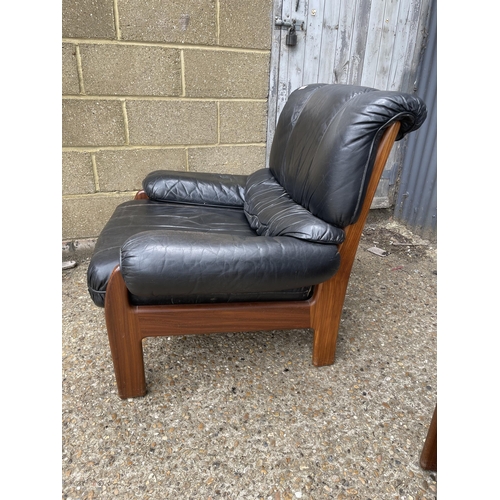 296 - A pair of mid 20th century teak framed armchairs with black leather seats