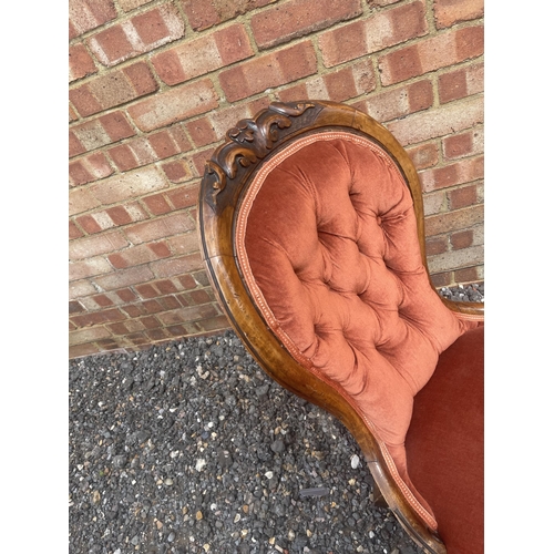 34 - A pink upholstered walnut framed Victorian spoon back Ladies chair together with a Victorian button ... 