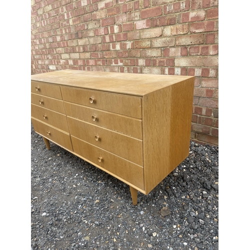 39 - A mid century light oak chest of 8 drawers 130x46 x 68