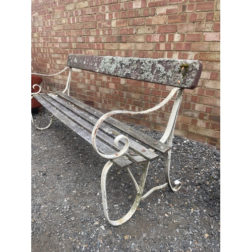 43 - A metal scrollwork garden bench with weathered hardwood slatted seat 180 cms