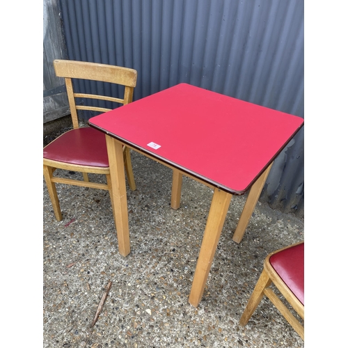 78 - A vintage red formica kitchen table with two chairs