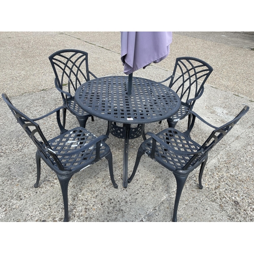 83 - A circular aluminum garden table together with four chairs and umbrella