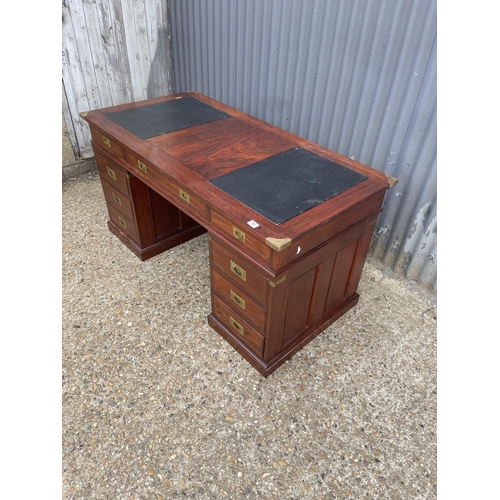 90 - A hardwood twin pedestal desk with brass mounts, military style brass handles and black leather surf... 