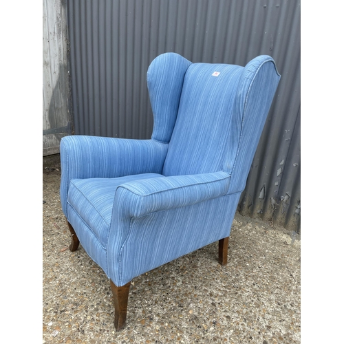 44 - A blue upholstered wing back armchair