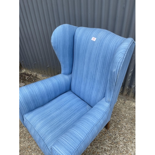 44 - A blue upholstered wing back armchair