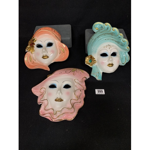 999 - Three brightly coloured porcelain face masks, longest 32 cms