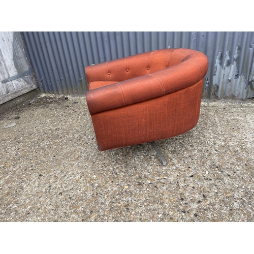 104 - A mid century g plan red upholstered swivel tub chair on star form base