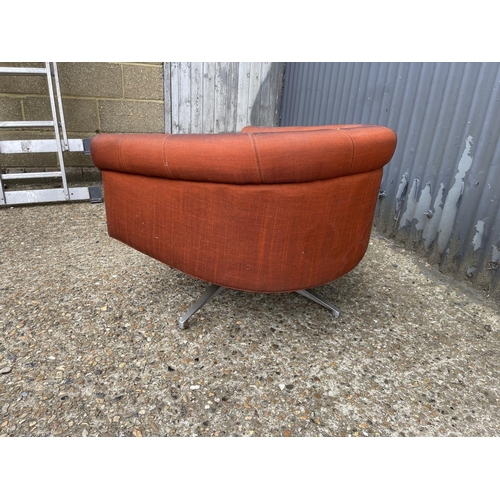 104 - A mid century g plan red upholstered swivel tub chair on star form base