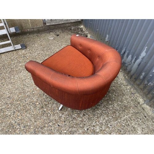 104 - A mid century g plan red upholstered swivel tub chair on star form base