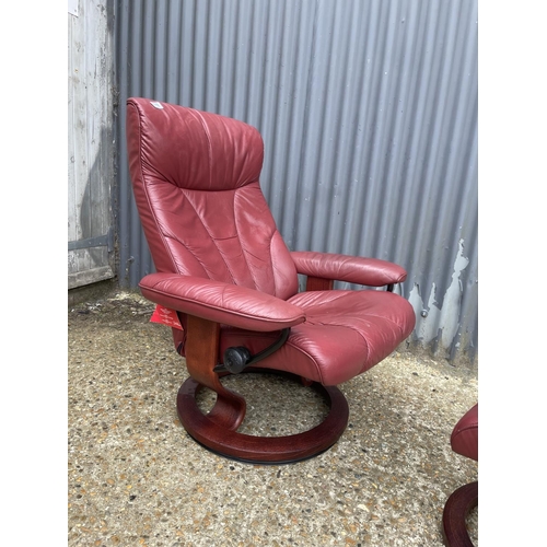 119 - A red leather stressless reclining armchair with stool