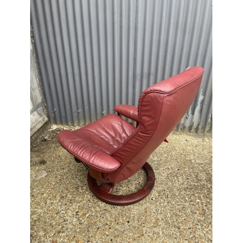 119 - A red leather stressless reclining armchair with stool