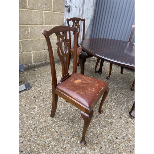 123 - An antique mahogany wind out oval dining table together with four chairs and two extension leaves