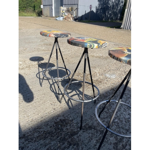 153 - A set of four chrome bar stools upholstered with MARVEL patterns to the seats