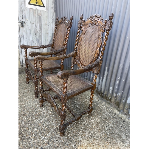 157 - A pair of carved oak throne style carver chairs with begere seats