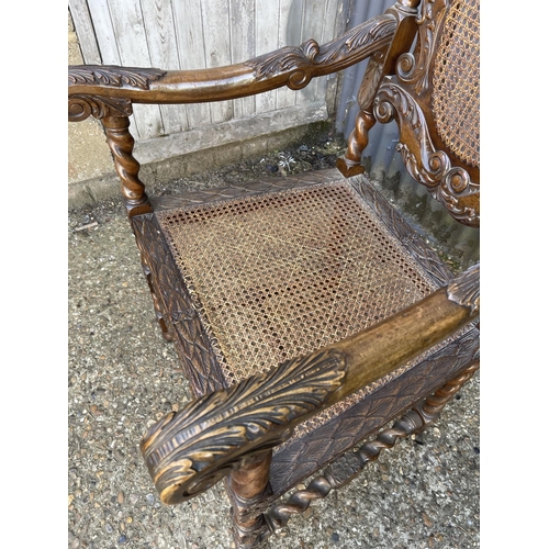 157 - A pair of carved oak throne style carver chairs with begere seats