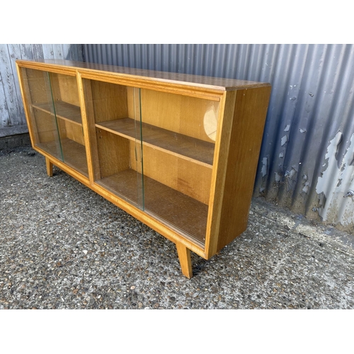 162 - A light oak double sided glazed bookcase 150cm