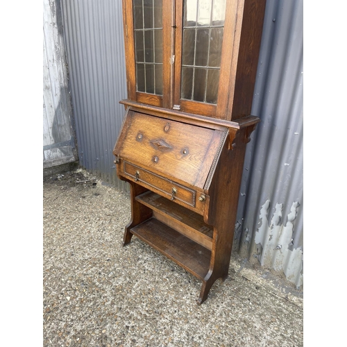 178 - A early 20th century oak bookcase cupboard with leaded glass top