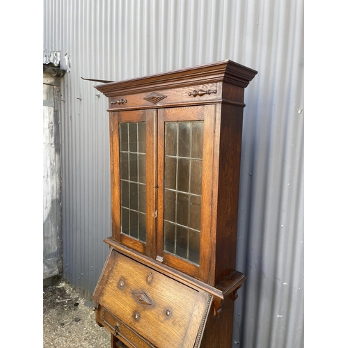 178 - A early 20th century oak bookcase cupboard with leaded glass top