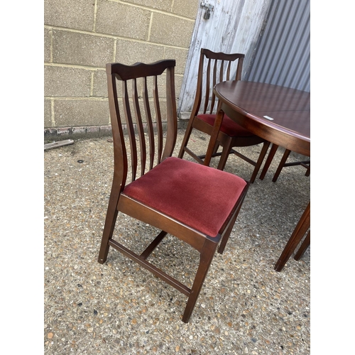 200 - A stag minstrel circular extending dining table with four matching chairs