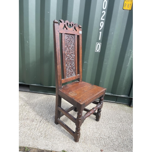 310 - A carved oak panel back chair