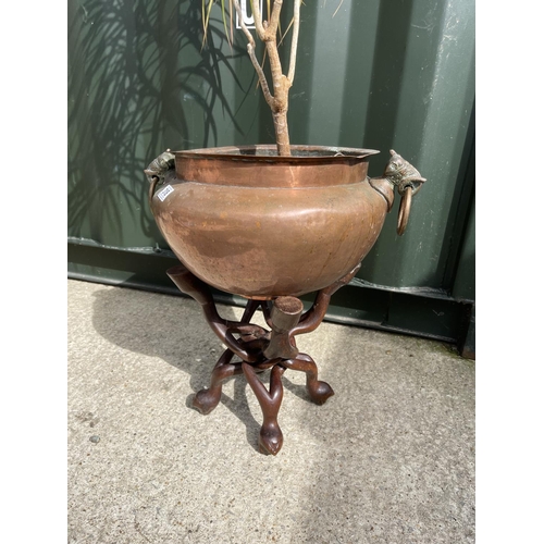 318 - A copper planter with house planted on folding hardwood stand