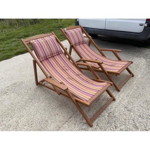 350 - A pair of hardwood deck chairs with striped seats