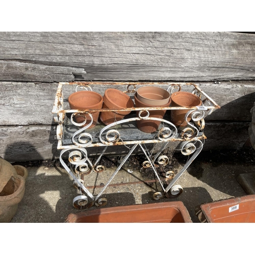 389 - A metal pot rack with small terracotta pots