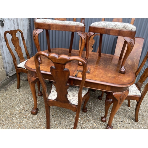 52 - A walnut ball and claw wind out extending dining table with one leaf and a set of six matching ball ... 