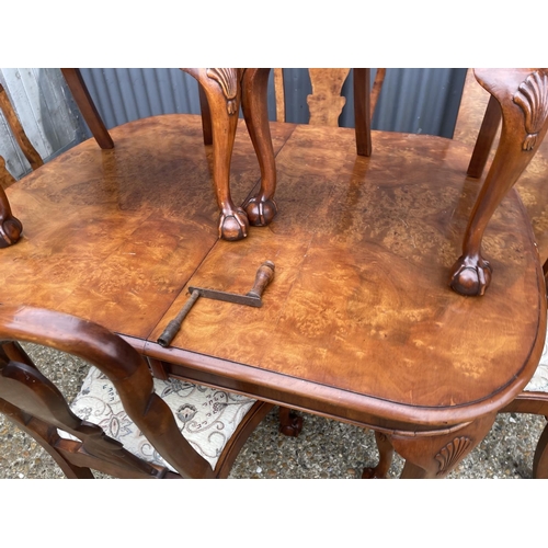 52 - A walnut ball and claw wind out extending dining table with one leaf and a set of six matching ball ... 