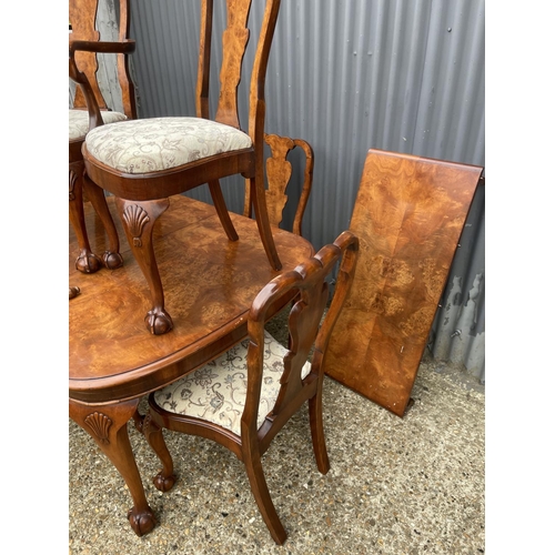 52 - A walnut ball and claw wind out extending dining table with one leaf and a set of six matching ball ... 