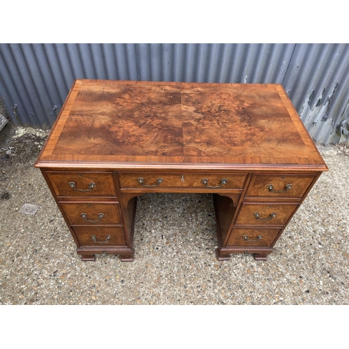 53 - A reproduction seven drawer kneehole writing desk with key 104x60 x75