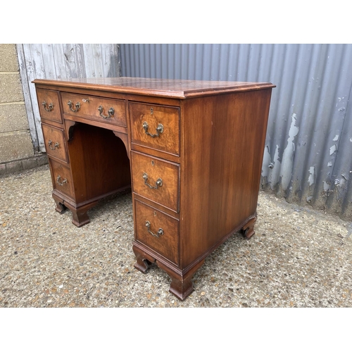 53 - A reproduction seven drawer kneehole writing desk with key 104x60 x75