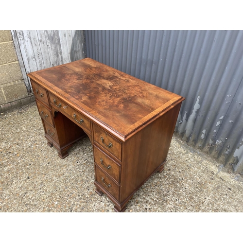 53 - A reproduction seven drawer kneehole writing desk with key 104x60 x75