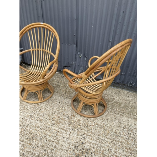 87 - A pair of bamboo swivel and spring recline chairs