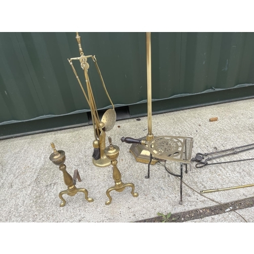 299 - A brass standard lamp together with brass fire dogs, trivet and tools