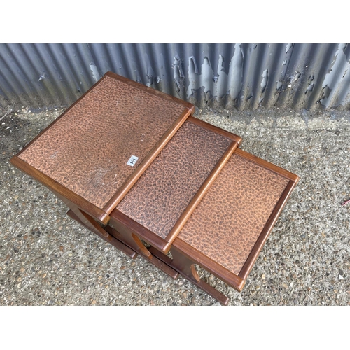 104 - A mid century teak nest of three with planished copper top