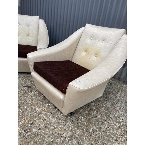 135 - A pair of mid century white vinyl armchairs