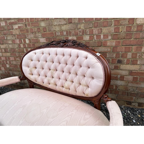 14 - A french style salon love seat with pink buttoned upholstery and decorative mahogany frame