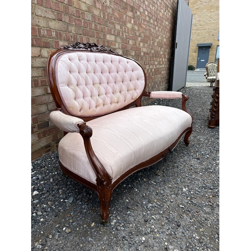 14 - A french style salon love seat with pink buttoned upholstery and decorative mahogany frame