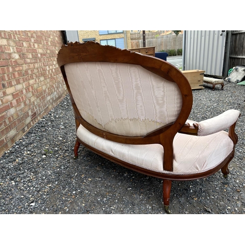 14 - A french style salon love seat with pink buttoned upholstery and decorative mahogany frame