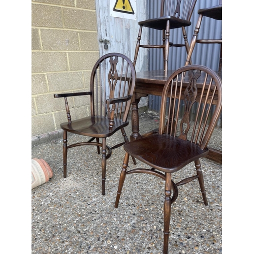 249 - An oak refectory dining table together with six stick back chairs (2 carvers) with crinoline stretch... 