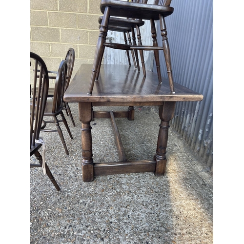 249 - An oak refectory dining table together with six stick back chairs (2 carvers) with crinoline stretch... 